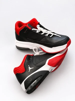 Svarta och röda Air Jordan sneakers - Snygga Air Jordan sneakers i svart och rött med vit sula och röda detaljer. Skorna har lågt skaft, klassisk Jumpman-logga på sidan och sulan, samt vita skosnören. Ovandelen är i läder och textil för en sportig look.