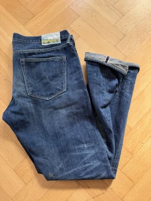 Selvage Jeans - Mörkblå Selvage jeans från The One. ungefär storlek 32/34. Sitter som en smäck och har helt otroliga fades i knävecken och under framfickorna. Att de är slevage gör att de kommer fadesen kommerformas som du bär dom i framtiden! 