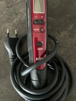 Plattång Braun Satin Hair Colour - Elektrisk plattång från Braun, modell Satin Hair Colour. Svart och vinröd design med digital display, boost-knapp och on/off-knapp. Utrustad med lång sladd och EU-kontakt. Perfekt för styling av håret hemma.mycket lite använd 