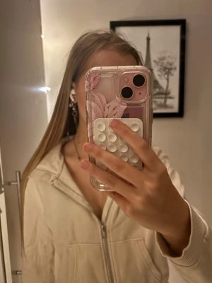 Beige hoodie med dragkedja - Säljer en beige hoodie med dragkedja framtill och huva. Hoodien har en clean look utan synliga loggor eller tryck, och är gjord i ett mjukt material som känns skönt mot huden. Perfekt för chill dagar eller när du vill ha en enkel och stilren outfit.