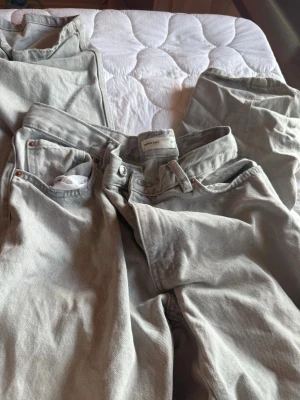 Mid waist Grå jeans - Ett par grå jeans som använts vid flera tillfällen men utan stora defekter. Kan enbart vara lite ”trasiga” längst nere vid benen, men tycker det kan även se lite ”snyggt” ut. Är kort därmed har de slitit lite där. Utöver det ingen defekt.