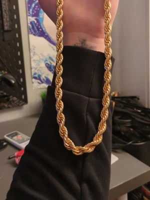 Tjockt guldfärgat cordell halsband 8MM - Säljer ett chunky halsband i guldfärgad metall med repkedje-design. Halsbandet har en vriden, robust kedja som ger en cool och trendig look. Perfekt för dig som vill sticka ut och addera lite extra bling till din outfit.