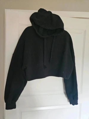 Hoodie Gina Tricot S - hoodie från Gina Tricot S  Svart croppad hoodie från Gina Tricot med huva och snörning. Tröjan har långa ärmar och ribbade muddar. Perfekt för en chill och avslappnad stil. Mjuk och skör bomullsblandning.  Kan även hämtas I Partille  E1