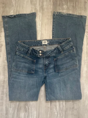Lågmidjade jeans - Säljer dessa mörkblåa lågmidjade jeansen med utsvängda ben. Det är en slitning längst ner på ena benet (se bild 3)🫶🏼 Storlek M, full lenght.