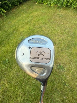 Cobra Gravity Back trä3 golfklubba - Säljer en Cobra Gravity Back 3-wood golfklubba med 15,5 graders loft. Klubban har ett klassiskt silverfärgat klubbhuvud i metall och svart skaft. Perfekt för dig som vill ha en stabil fairwayklubba till golfbanan.
