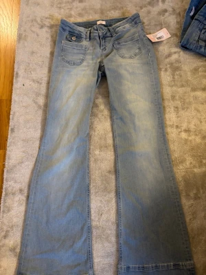 Ljusblå bootcut jeans med fickdetaljer -  ljusblå bootcut jeans med coola fickdetaljer.