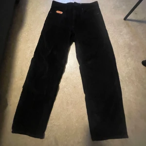 Svarta manchesterbyxor från Empyre  - Snygga svarta manchesterbyxor från Empyre med en cool broderad logga på fickan. Byxorna är i loose fit och är perfekta för en stilren look. Skick 10/10 || strlk W28. De är tillverkade i mjukt manchestertyg som ger en skön känsla. Priset kan sänkas vid snabb affär.
