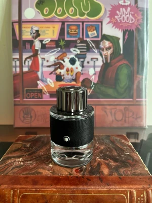 Montblanc Explorer Eau De Parfum parfym 60ml - Montblanc Explorer parfym i en elegant rund glasflaska med svart texturerat hölje och silverfärgat lock. Flaskan har Montblancs ikoniska stjärnlogo på framsidan och locket är dekorerat med märkets namn. Perfekt för dig som gillar stilrena och exklusiva dofter.Doften ska efterlikna Creed Aventus.  (45/60 ml kvar i flaskan)