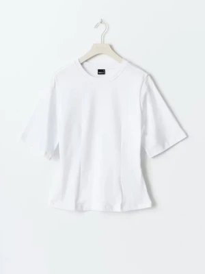 Vit figursydd t-shirt i bomull - En klassisk vit t-shirt med rund hals och korta ärmar. Tillverkad i mjuk bomull, perfekt för en enkel och clean look. Passar till allt och är ett måste i garderoben. En liten fläck i fram som knappt syns se bild 