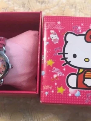 Hello Kitty rosa klocka i presentask - Söt Hello Kitty klocka med rosa armband och matchande presentask. Klockan har ett färgglatt motiv på urtavlan och detaljer i silver. Perfekt för dig som gillar gulliga accessoarer och vill sticka ut lite extra. Nya klocka med nya batterier, finns fler kvar 