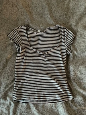 Randig ribbad topp med v-ringning - Säljer en kortärmad topp med svartvita ränder och ribbad struktur. Toppen har en snygg v-ringning och sitter figurnära, även lite kortare modell. Perfekt nu till hösten 🤍❤️