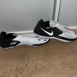 Nike phantom flyease str.41 - Ett par oanvända (bara testade) Nike phantom flyease fotbollsskor. Perfekta för anfallare, skorna ska ha bra grepp och är till stor hjälp för en person som ska driva fram bollen. Perfekt för den som springer mycket på planen. Jag gav 800kr för dom.