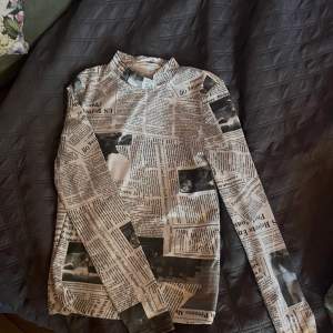 En tröja med tidnings tryck  i strechigt material