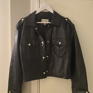 Svart skinnjacka strl strl 38 - Säljer denna supercoola skinnjacka i ormskinns  inspirerat mönster. Säljer för 199kr plus frakt.