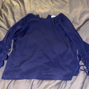 Marinblå blus storelk 40 - Marinblå blus som använts ca 5 gånger. Bra skick. Fina detaljer på armarna. Ganska lite i storlek (jag brukar vara en M)