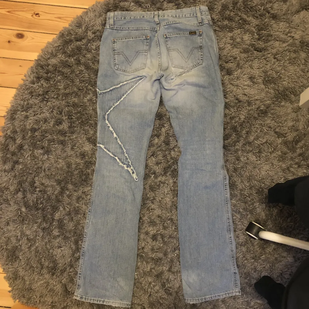 Ljusblå jeans från crocker med en stjärna på benet, lite slitna med lös knapp men sjukt coola ändå! Frakt tillkommer på 63kr midjemått: 72cm Innerbenslängd: 85cm . Jeans & Byxor.