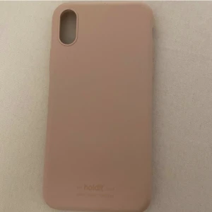 Holdit skal iPhone X - Hej!🥰 säljer denna holdit skal i färg gammelrosa. Till iPhone X.  Den är knappt använd, men den gick sönder lite som ni kan se på bild 2 men man märker inte det när man väll har skalet på. Säljer pågrund av att den inte kommer till någon användning. 