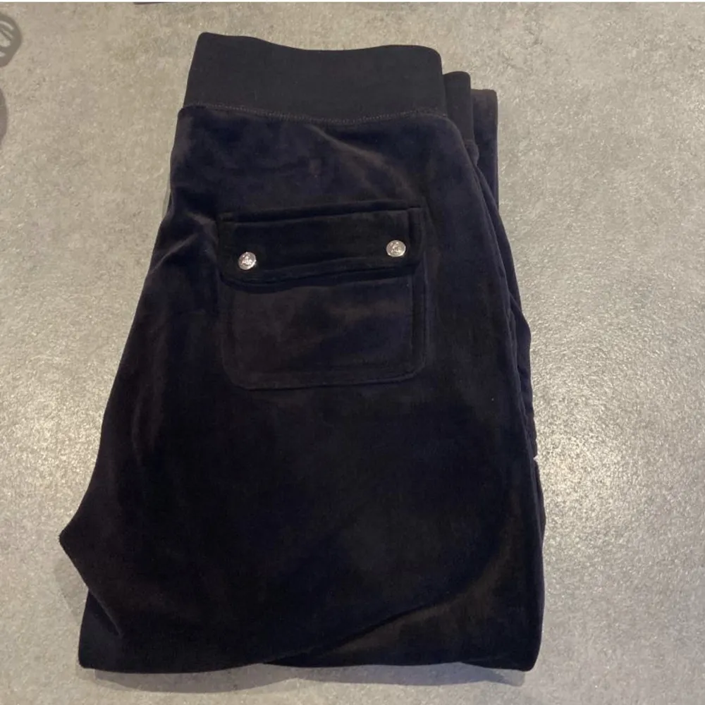Svarta Juicy Cuture byxor i storlek S. Fina men begagnat skick. Det finns två små fläckar under ena fickan, se bild. Lite slitna längst ner på byxbenen då dom är långa. 450+ frakt. Jeans & Byxor.
