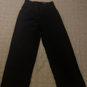 Svarta Kostymbyxor  - Ett par vida svarta kostymbyxor. Knappt använda och i gott skick. Med dragkedja och knapp. 