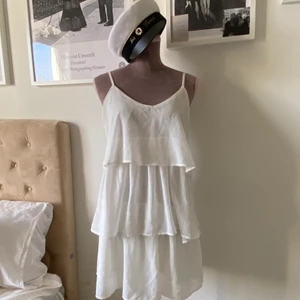 Vit volangklänning från Nelly  - Enkel och klassisk studentklänning feån Nelly med djup rygg! Passar 34, 36 & 38