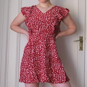 Kort sommarklänning i storlek 36/S - Härlig sommarklänning i rött med vita prickar och öppen rygg. Midjan är i resår. Aldrig använd. Personen på bilden är 159 cm. 