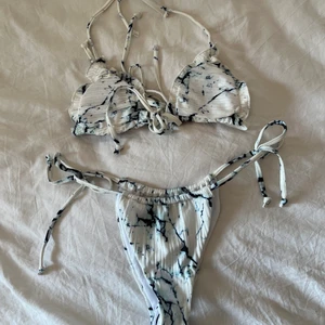 Helt ny vit grön marmor bikini strl S - Helt ny bikini i vit/grönblå marmor mönster. Strl S, aldrig använd, intimskydd kvar. Uttagbara pads, knyts vid brösten, i nacken och i ryggen, justerbara bikinitrosor, väljer själv hur mkt string. Frakt 52kr💕