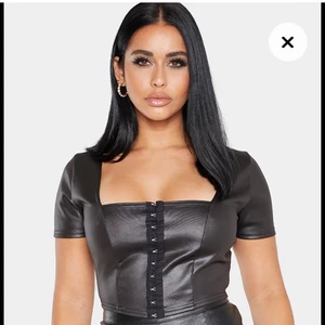 Festtopp från Pretty Little Thing - Säljer denna snygga topp från PLT, den är i PU leather (bilder från deras hemsida). Aldrig använd! Jättefin att ha både till vardags och fest. Slutsåld!