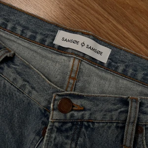 Samsoe ljusblå slitna straight fit jeans  - Skitsnygga jeans med slitna detaljer vid byxbenet och bakfickorna, passar någon som är runt 183 cm, straight fit, strl 32 men en stor 32, kan tänka mig gå ner i pris