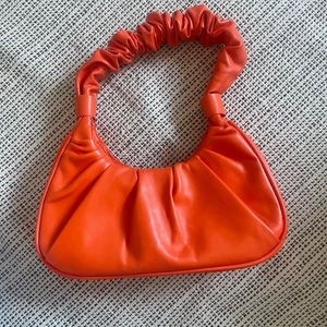 Orange väska  - Säljer denna otroligt fina väskan. Har dragkedja inuti och magnet som stänger väskan. 