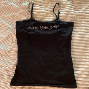 Calvin Klein linne - Linne med strass! Väldigt mycket bratz.. storlek l men sitter figurnära på mig med m. Har dubbelt tyg mot brösten så bh behövs ej