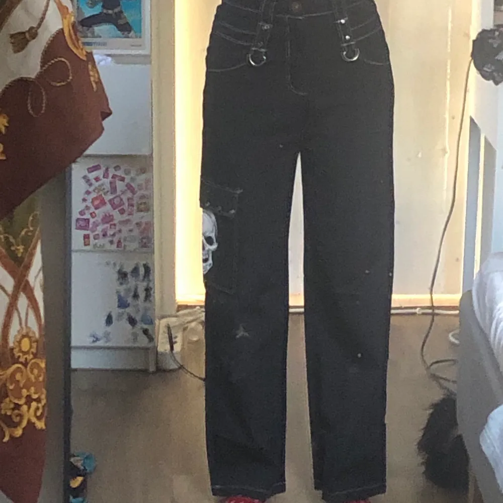 Svarta byxor med döskalle ficka på höger sida . Jeans & Byxor.