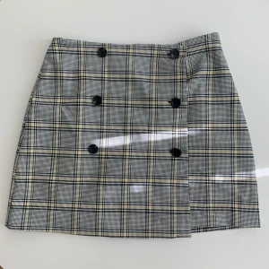 Grå/gul rutig kjol storlek 38 - Jättefin stilren kjol, storlek 38. Säljer då den inte passar mig längre, endast använt fåtal gånger. 