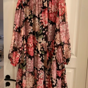 Långärmad klänning strl XL - Långärmad blommig sommarklänning med ett undertyg och fin knäppning i ryggen.