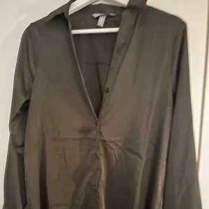 Satin skjorta - Säljer min fina mörkgröna satin skjorta använd vid 1 tillfälle, hur fin som helst t sommaren med nån spets bh under💕