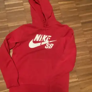 Säljer denna röda Nike hoodien. Skicket är 5/10 på grund av att det är hål i båda änderna av armarna men kan fixas om man syr de. Kostar 120kr + 66kr frakt
