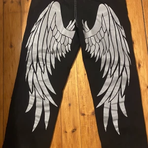 Jeans - Super coola jeans med tryck där bak. Nästa aldrig använt bra skick. Tryck inte på köp nu!!!