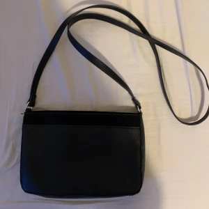 Svart väska  - Gullig svart väska från h&m använd ca 1-2 gnr men kommer tyvärr inte till användning längre därav säljs den