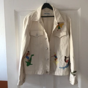 Jeansjacka  - Jeansjacka i dirty white med insydda motiv. Strl L. Jag är S och har använt som oversized. 