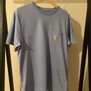 Carhartt t-shirt gråblå/babyblå - En jättesnygg carhartt t-shirt i jättebra skick. Storlek M. Nypris 439kr. Köpare står för frakt. 