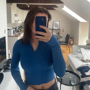 Blå croppad tröja  - Supersnygg och skönt blå croppad tröja. Med en snygg zip dragkedja.