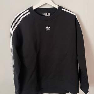 En oanvänd sweetshirt från Adidas med en lite logo på bröstet och ”the 3 stripes” på ärmarna. Strl. small