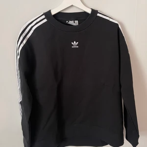 Adidas - En oanvänd sweetshirt från Adidas med en lite logo på bröstet och ”the 3 stripes” på ärmarna. Strl. small