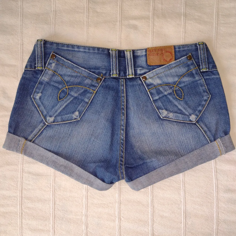 Korta blå lågmidjade jeansshorts från Blue Blue. Så snygga! Med slitningar och dekorativa sömmar. 100% bomull. Storlek 28. . Shorts.