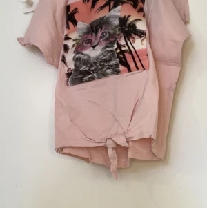 H&M t-shirt med kattryck, strl: 146/152  - Bra skick, inte använts så många gånger pga för liten. Rekommenderas för 10-12 år. 