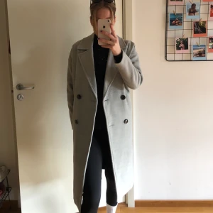 Grå kappa till hösten  - En fin grå kappa från Vero Moda, perfekt till hösten. Går till vaderna ungefär på mig som är 170. Är en XS men passar S också. Nästan som ny! 🤍 Tryck inte på ”köp direkt” utan skriv om ni är intresserade!