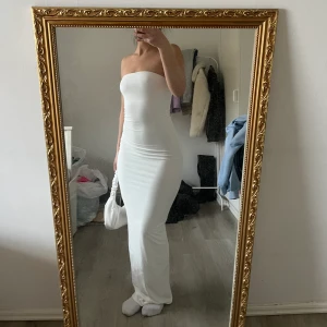 Bandeau maxiklänning - Vit bandeau maxiklänning, bodycon fit, aldrig använd! Köpt i somras, lite genomskinlig som syns på bild 2 