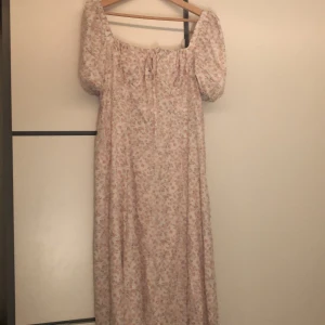  klänning  - Vit midi klänning med rosa blommor och slits på en sida. Helt ny aldrig använt pris lappen är kvar :)