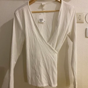 Omlottröja - Omlottröja från H&M. Aldrig använd, prislappen är kvar. Storlek L men skulle även passa en M.