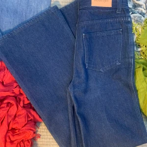 Rodebjer Hall jeans stl 27 - Klassiska Rodebjer Hall i mörkblå denim, 100% bomull. Är i mycket gott skick, inga tydliga defekter. Endast tvättade en gång. Hög midja, raka vida byxben. Storlek 27, midjemått ca 74-76 cm, innerbenslängd 88 cm. Ordinarie pris 1795 kr.