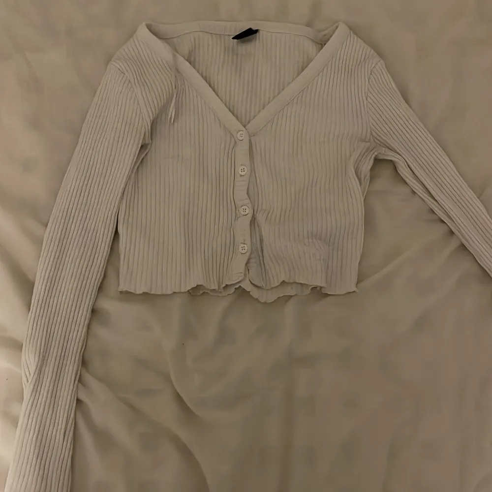 Vit långärmad tröja med knappar där framme, från Gina storlek xs. Toppar.